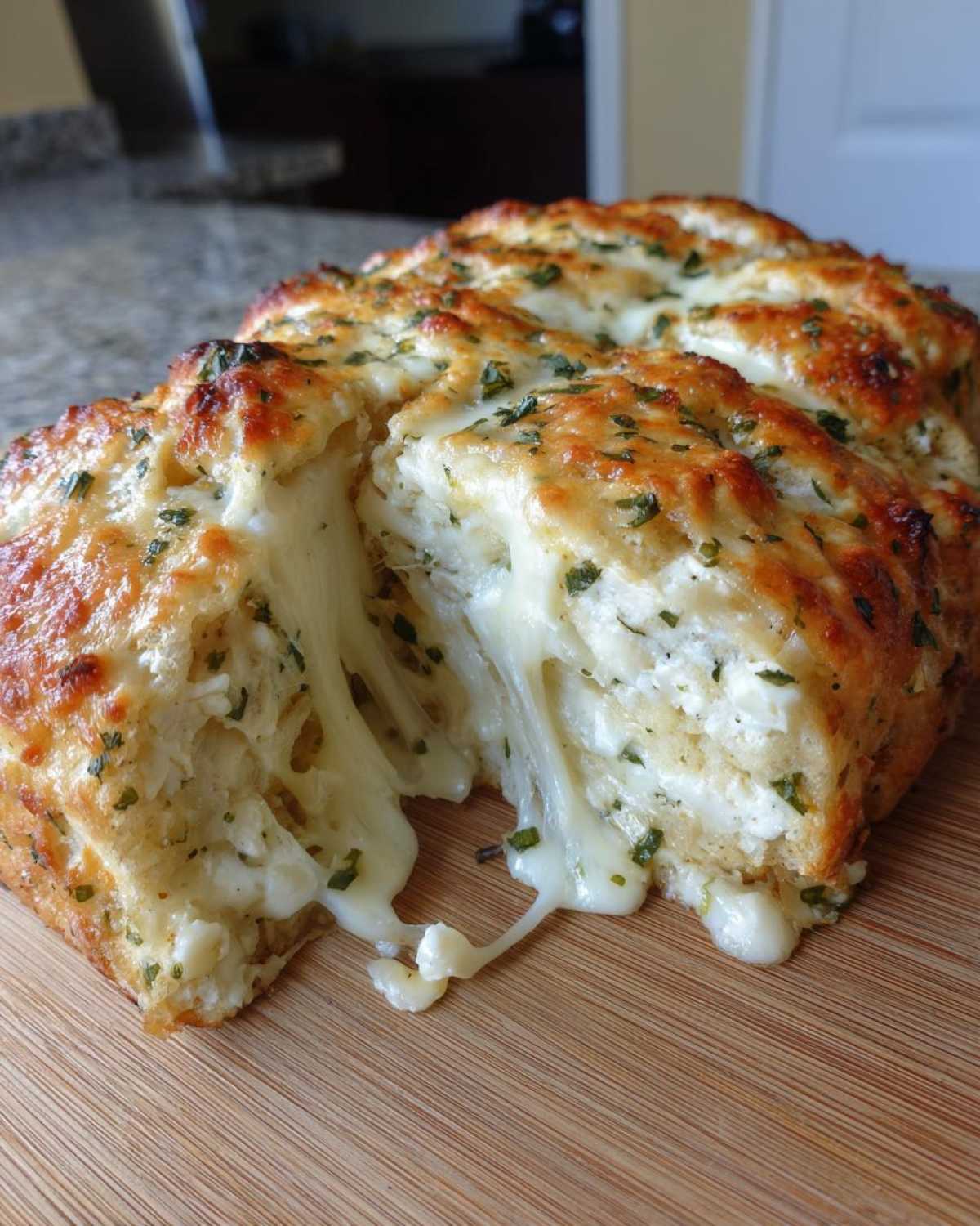 Close-up of Cheesy Garlic Chicken Rolls being pulled apart, revealing extreme cheese stretch and herbs.