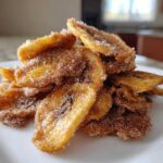 Close-up of a stack of crispy Cinnamon Sugar Banana Chips heavily coated in cinnamon and sugar mixture.