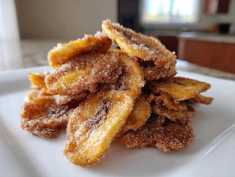 Close-up of a stack of crispy Cinnamon Sugar Banana Chips heavily coated in cinnamon and sugar mixture.