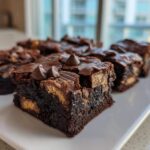 Close-up of fudgy Kit Kat Brownies cut into squares, topped with chocolate chips.