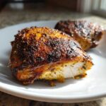 Close-up of a juicy Garam Masala Chicken Thighs piece, showing the perfectly cooked white interior and dark, spiced crust.