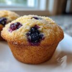Close-up of a freshly baked Lemon Blueberry Muffin topped with coarse sugar.