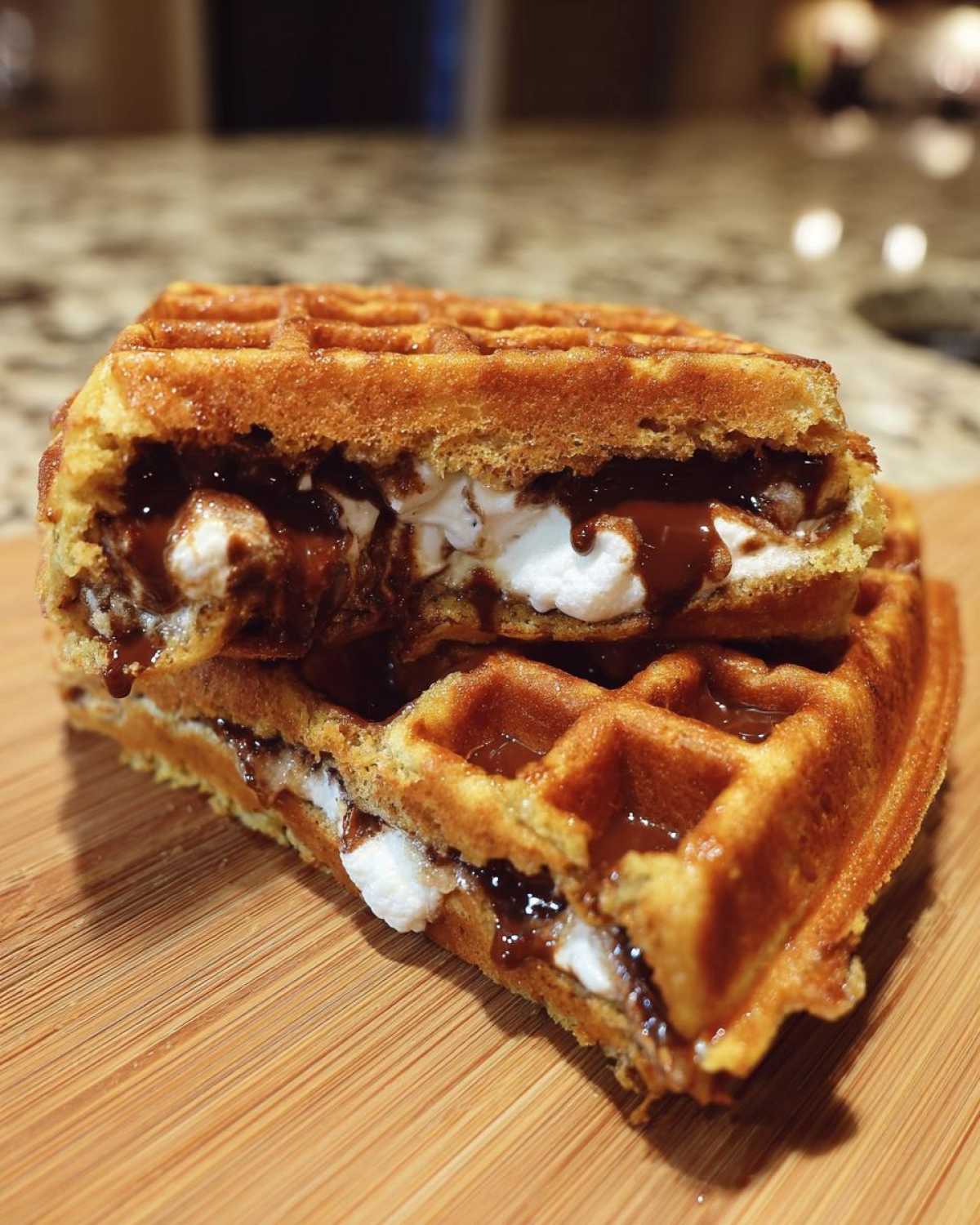 Close-up of a Marshmallow Chocolate Lava Waffle Bomb cut in half, showing gooey chocolate and melted marshmallow filling.