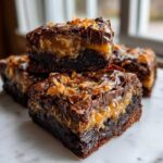 Close-up of rich, layered Samoa Box Mix Brownies featuring a thick caramel layer and toasted coconut topping.