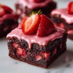A single, rich Strawberry Brownies with Sweet Strawberry Glaze square topped with pink icing and fresh sliced strawberries.