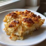 A close-up of a rich slice of Tennessee Onions Gratin, showing layered onions baked in cream with a golden brown, crispy topping.