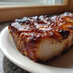Close-up of a thick, juicy piece of Grilled Honey Mustard Chicken Breast with a caramelized, shiny glaze.