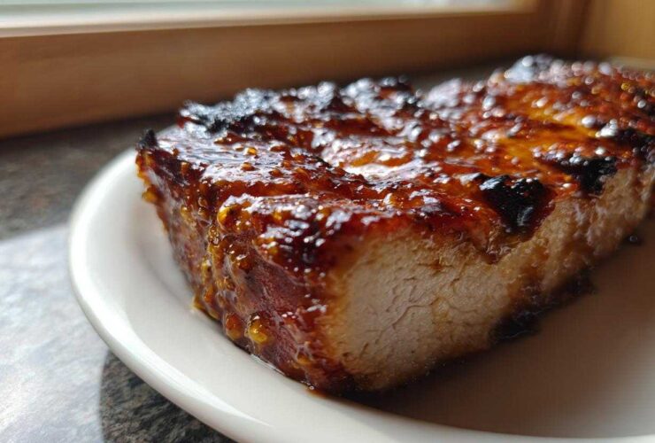 Close-up of a thick, juicy piece of Grilled Honey Mustard Chicken Breast with a caramelized, shiny glaze.