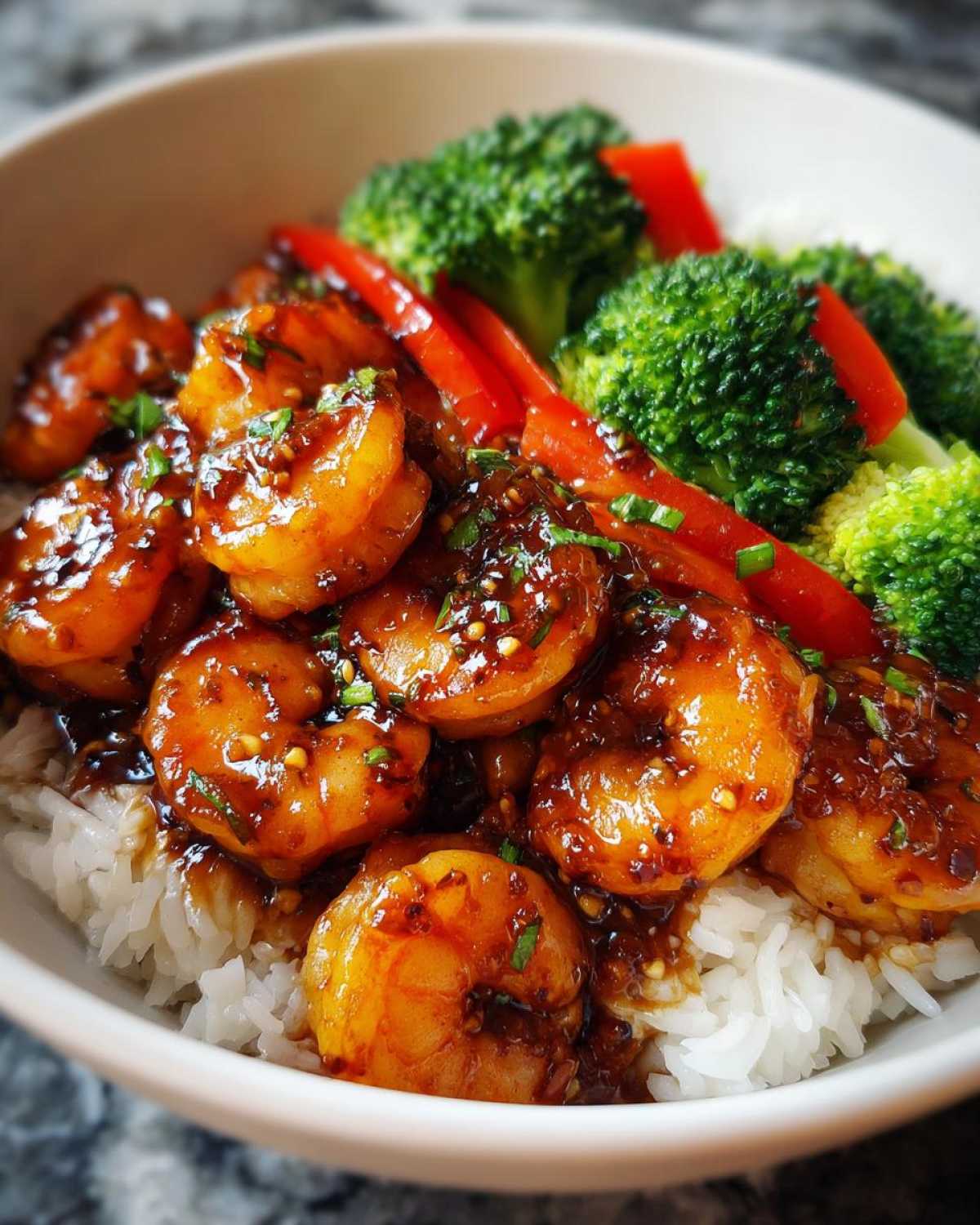 Close-up of Honey Garlic Shrimp Bowls featuring saucy shrimp over rice with steamed broccoli and red peppers.