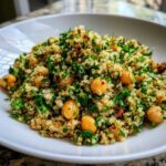 A close-up of the Jennifer Aniston Salad featuring quinoa, chickpeas, and fresh parsley served on a white plate.