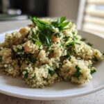 A close-up view of the Jennifer Aniston Salad featuring fluffy quinoa, chickpeas, and fresh parsley on a white plate.