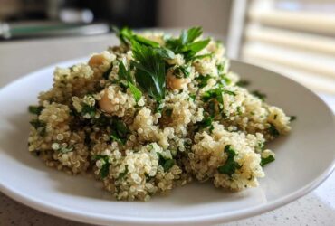 A close-up view of the Jennifer Aniston Salad featuring fluffy quinoa, chickpeas, and fresh parsley on a white plate.