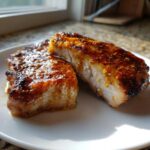 Two thick cuts of juicy Grilled Honey Mustard Chicken Breasts, glazed and slightly charred, resting on a white plate.