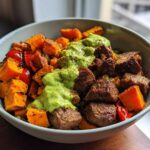 Close-up of Steak and Sweet Potato Bowls topped with a bright green Avocado-Cilantro Drizzle.